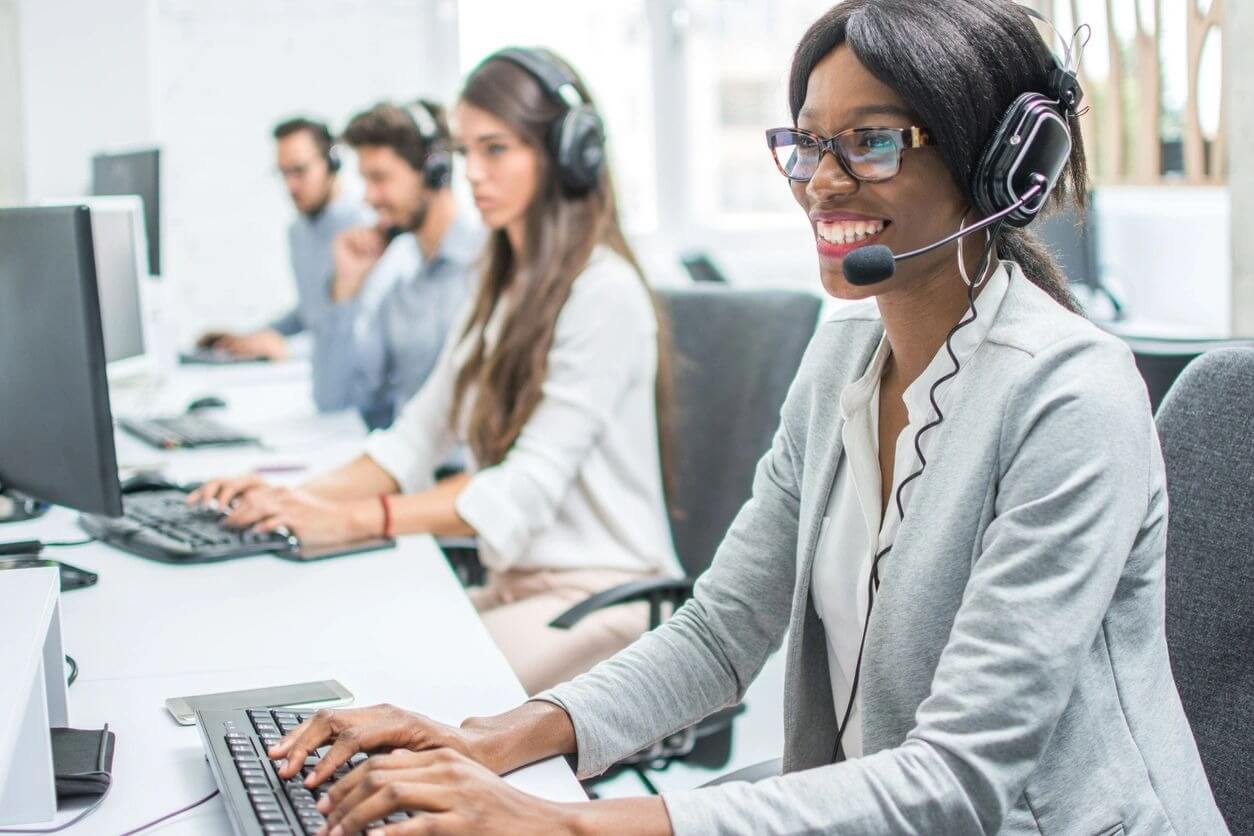 Customer service representative typing and smiling
